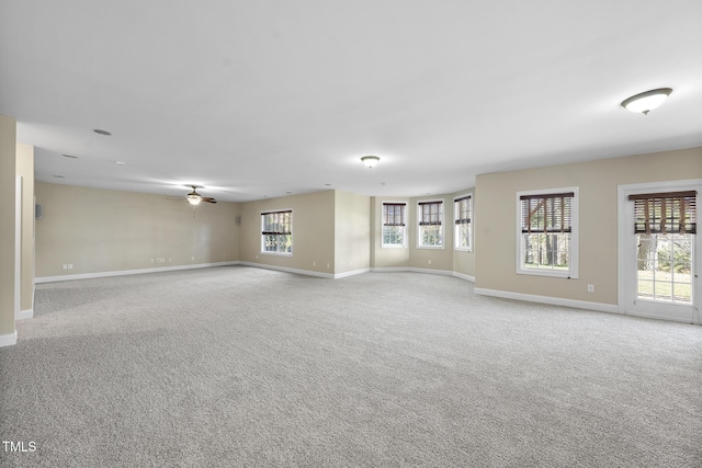 unfurnished room featuring carpet, baseboards, and a ceiling fan