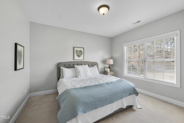 carpeted bedroom with visible vents and baseboards