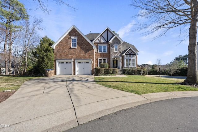 tudor home with brick siding, concrete driveway, an attached garage, stone siding, and a front lawn