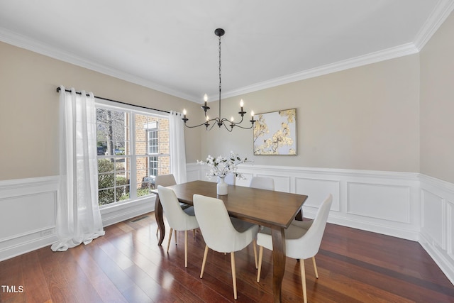 dining room with ornamental molding, dark wood-style flooring, wainscoting, and visible vents