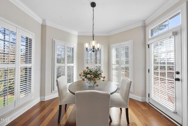 dining room featuring crown molding, baseboards, a notable chandelier, and wood finished floors