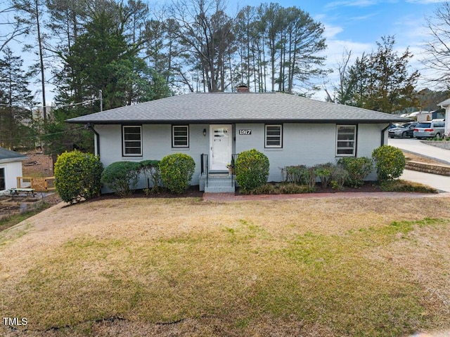 single story home with brick siding, a chimney, a front lawn, and roof with shingles