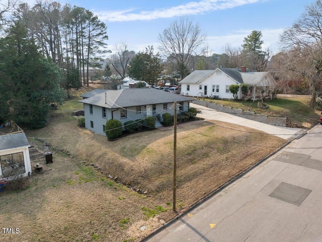 view of front of house with concrete driveway and a front lawn