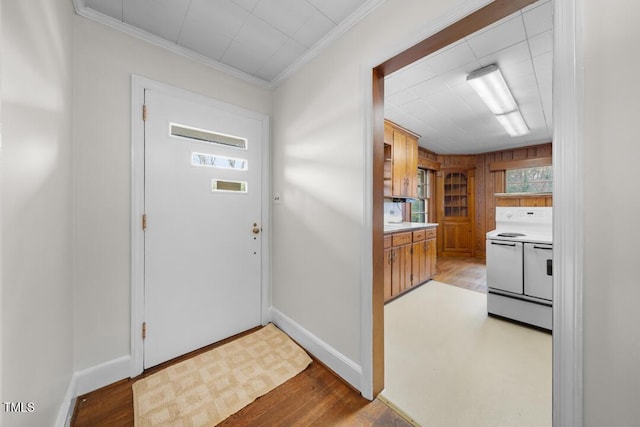 entrance foyer featuring baseboards, ornamental molding, and wood finished floors