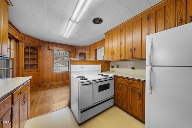 kitchen with light countertops, white appliances, and brown cabinets