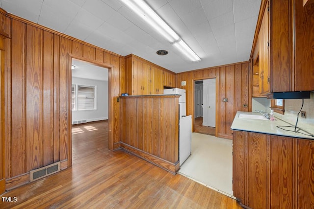 kitchen featuring visible vents, brown cabinets, and a sink