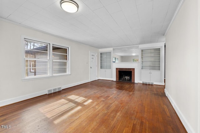 unfurnished living room with a brick fireplace, baseboards, visible vents, and wood-type flooring