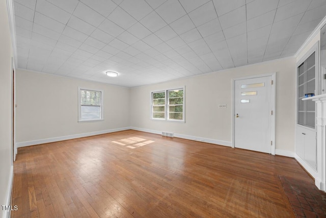 interior space featuring baseboards, visible vents, and hardwood / wood-style floors