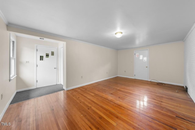 foyer entrance with wood-type flooring, crown molding, and baseboards