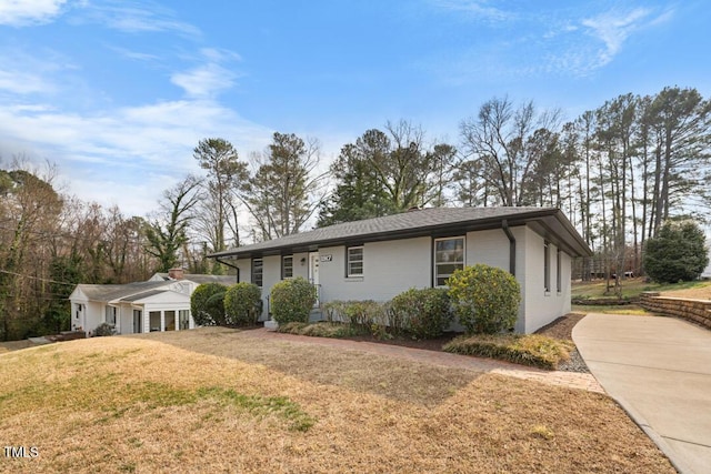 ranch-style home with a front lawn and concrete driveway