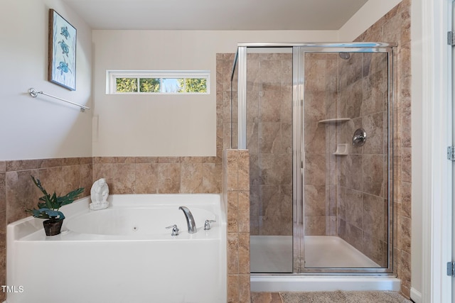 bathroom featuring a stall shower and a bath