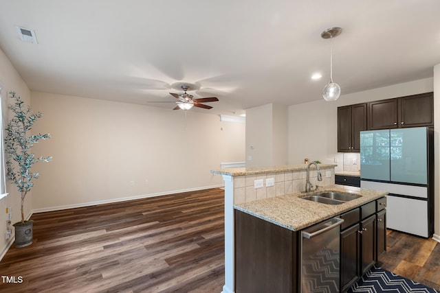 kitchen featuring dark wood-style flooring, visible vents, stainless steel dishwasher, freestanding refrigerator, and a sink