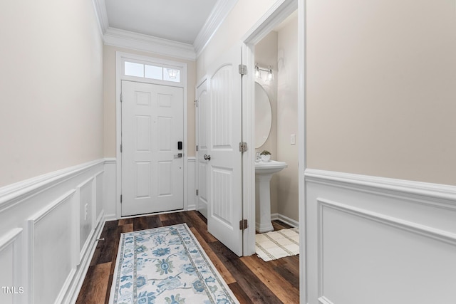 entryway with ornamental molding, a wainscoted wall, a decorative wall, and dark wood-style floors