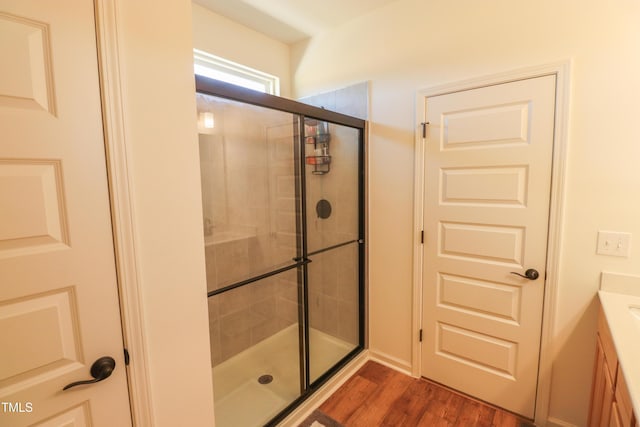 bathroom featuring a stall shower, vanity, and wood finished floors