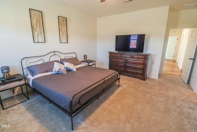 bedroom with baseboards, ceiling fan, visible vents, and light colored carpet