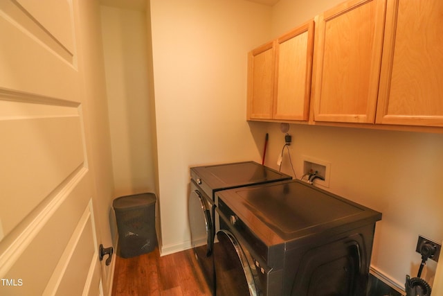 laundry area with cabinet space, washing machine and dryer, baseboards, and dark wood finished floors