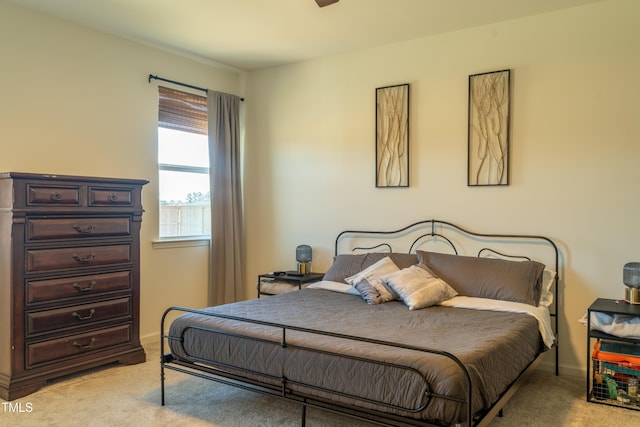 bedroom featuring light carpet and baseboards