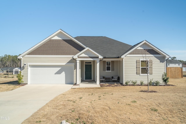 view of front of home with a garage, concrete driveway, a front lawn, and fence