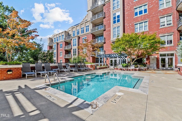 view of swimming pool with french doors and a patio area