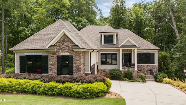 craftsman house featuring stone siding, crawl space, and roof with shingles