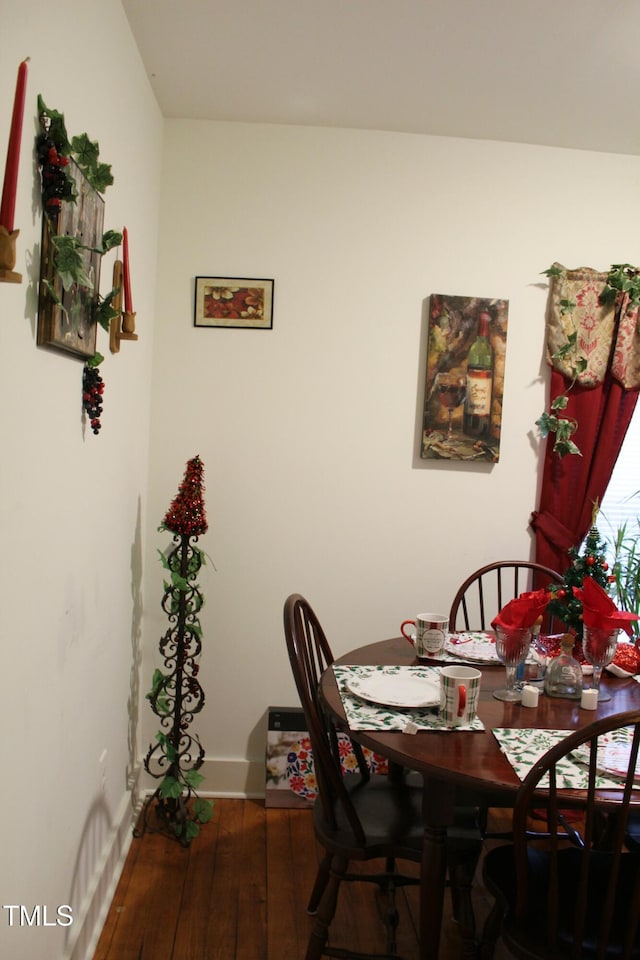 dining space with hardwood / wood-style flooring and baseboards