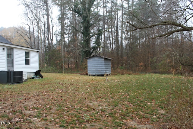 view of yard featuring a storage shed, central AC, and an outdoor structure