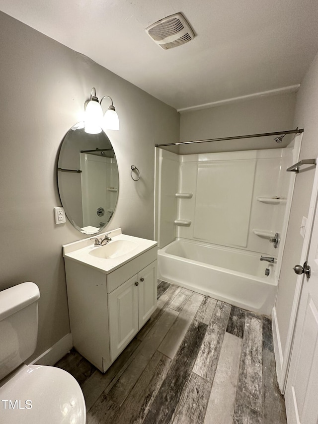 bathroom with visible vents, toilet, wood finished floors, tub / shower combination, and vanity