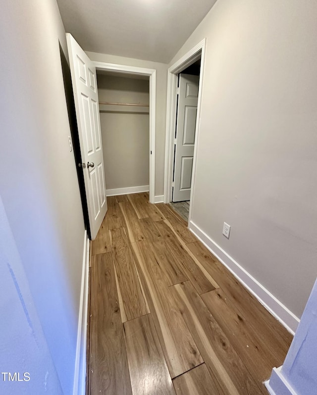 interior space featuring a closet, wood finished floors, and baseboards