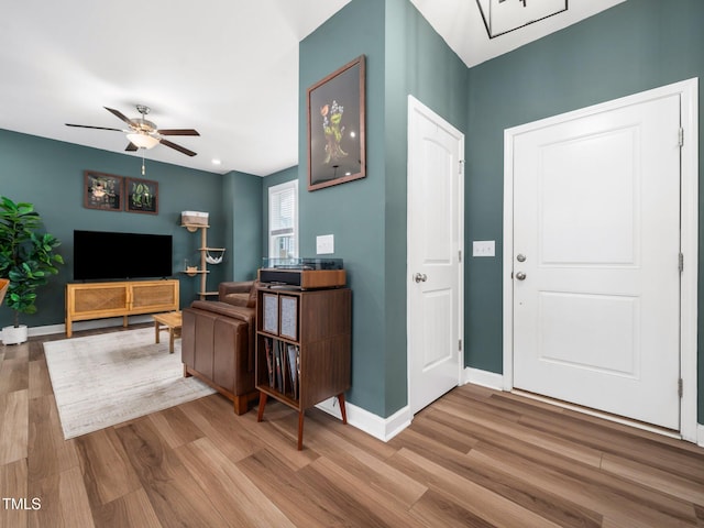 entryway featuring ceiling fan, wood finished floors, and baseboards