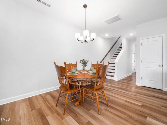 dining area featuring light wood finished floors, visible vents, and baseboards