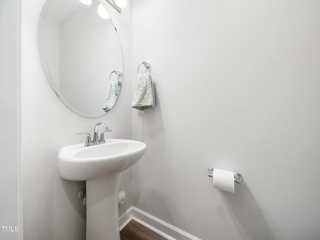 bathroom with baseboards and wood finished floors