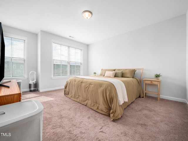 bedroom with multiple windows, baseboards, and carpet flooring