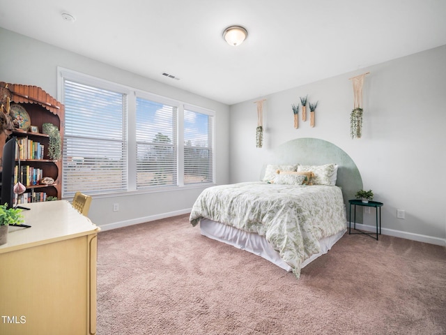 carpeted bedroom featuring baseboards and visible vents