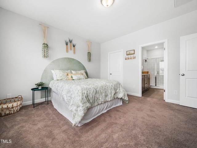 carpeted bedroom featuring visible vents, baseboards, and ensuite bathroom