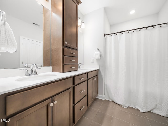 full bathroom with double vanity, tile patterned flooring, visible vents, and a sink