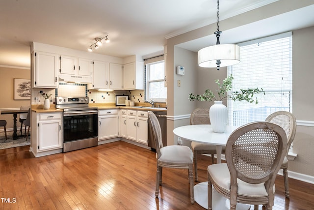 kitchen featuring stainless steel appliances, hardwood / wood-style flooring, and under cabinet range hood