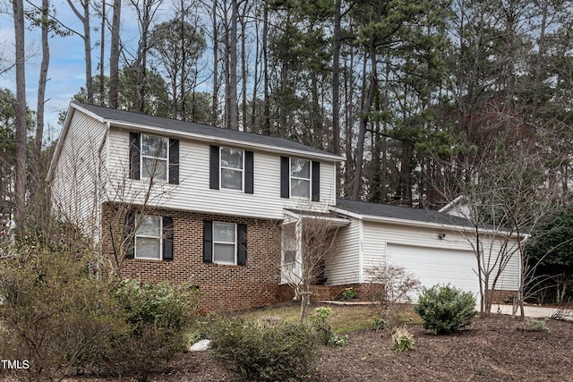 colonial-style house featuring a garage and brick siding