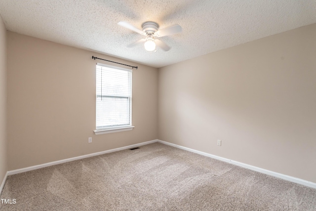 empty room featuring carpet, visible vents, ceiling fan, and baseboards