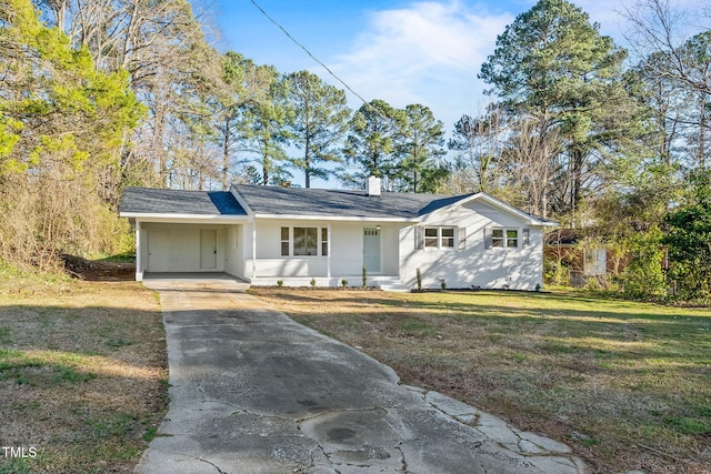 ranch-style house featuring driveway, a chimney, a carport, and a front yard