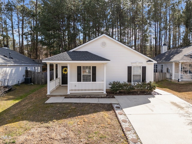 view of front of property featuring covered porch, fence, and a front lawn