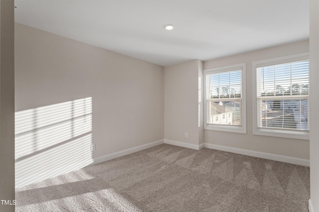 unfurnished room with carpet floors and baseboards