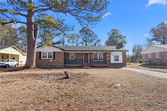 single story home with brick siding and a chimney