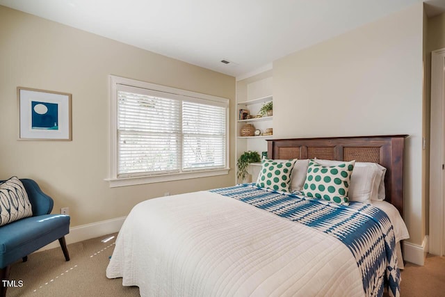 bedroom featuring light carpet, visible vents, and baseboards