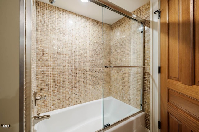 bathroom featuring combined bath / shower with glass door