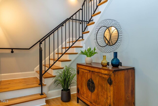 stairway featuring wood finished floors and baseboards