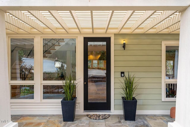 property entrance with a pergola