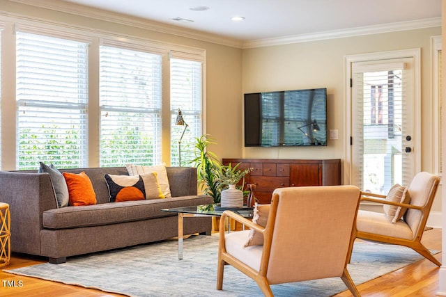 living room featuring visible vents, wood finished floors, and crown molding