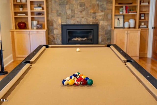 recreation room with pool table, wood finished floors, and a fireplace