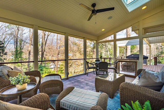 sunroom / solarium with lofted ceiling with skylight and ceiling fan