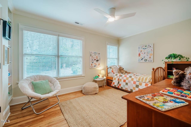 bedroom featuring visible vents, wood finished floors, baseboards, and ornamental molding